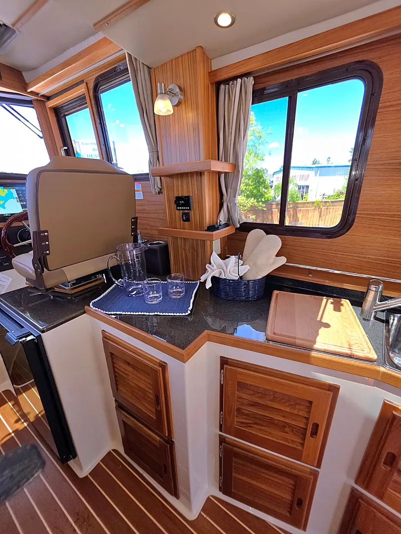 Slide: The Image of Interior of 2025 Ranger Tugs R-31 CB, featuring wood cabinetry and modern amenities. - 14