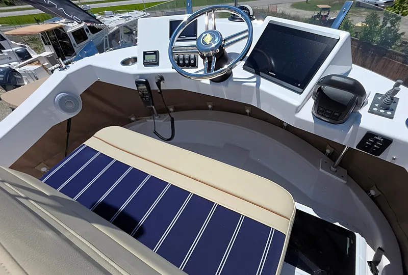 Slide: The Image of 2025 Ranger Tugs R-31 CB helm with modern controls and striped seating. - 4