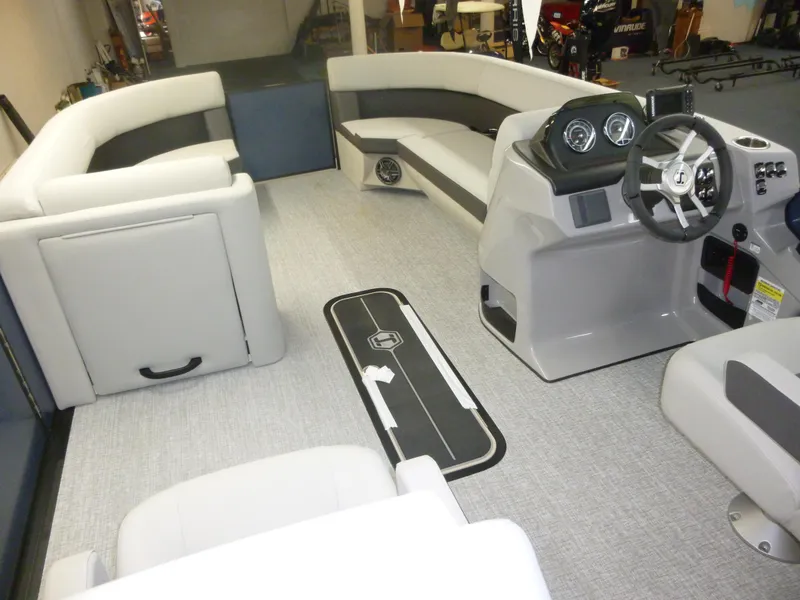 Slide: The Image of Interior of 2025 Harris CX 230 pontoon boat with modern seating and steering console. - 1