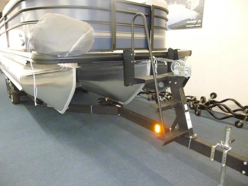Slide: The Image of 2025 Harris CX 230 pontoon boat on trailer, indoor display. - 10