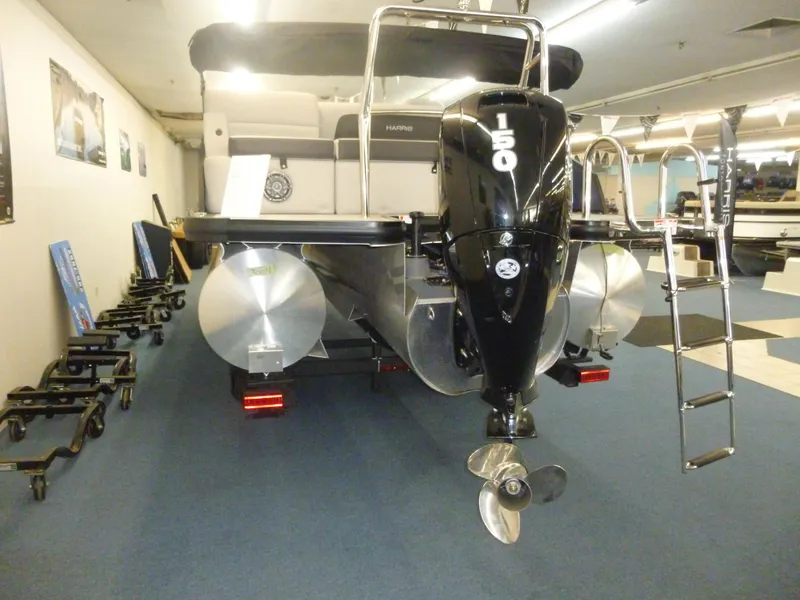 Slide: The Image of 2025 Harris CX 230 pontoon boat with 150 HP engine in showroom. - 11