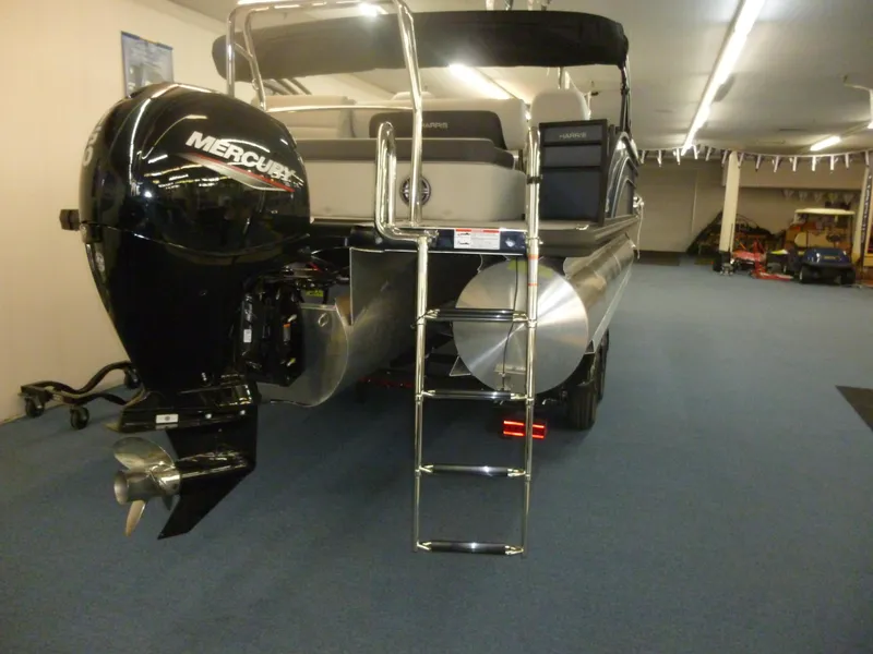 Slide: The Image of 2025 Harris CX 230 pontoon boat with Mercury outboard motor and ladder in showroom. - 12