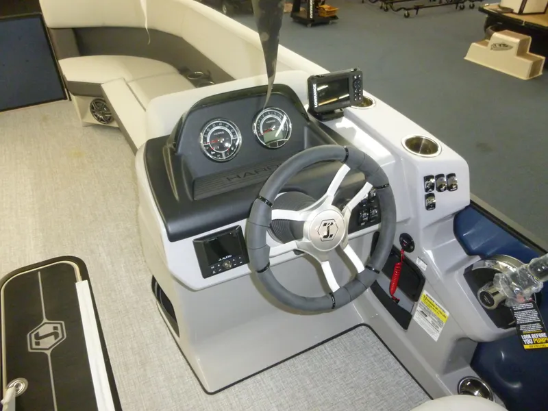 Slide: The Image of Interior of 2025 Harris CX 230 boat featuring steering wheel and dashboard controls. - 6