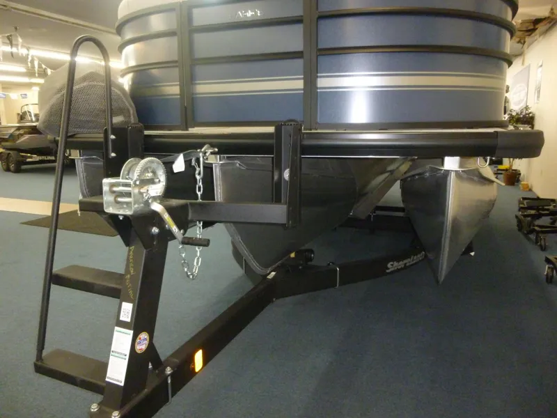 Slide: The Image of 2025 Harris CX 230 pontoon boat on trailer in showroom. - 9