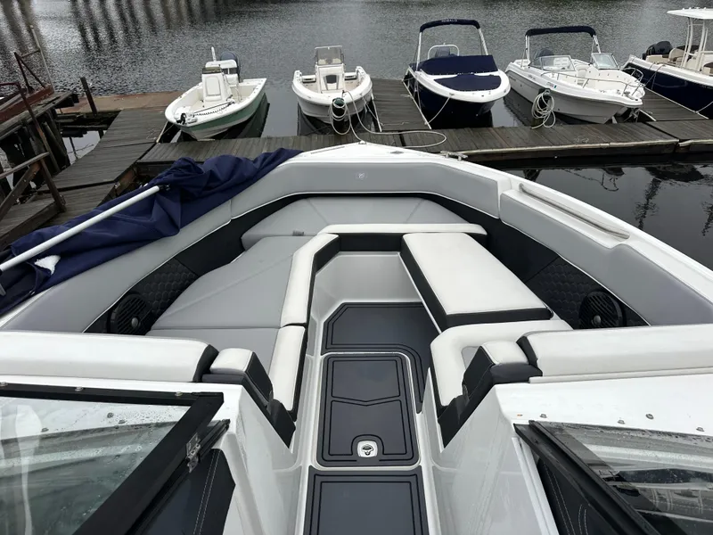 Slide: The Image of 2022 Cobalt R8 Surf boat with sleek seating at a marina dock. - 15