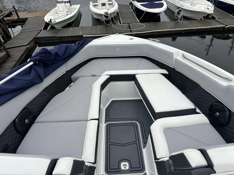 Slide: The Image of 2022 Cobalt R8 Surf boat interior with sleek seating at a dock. - 16