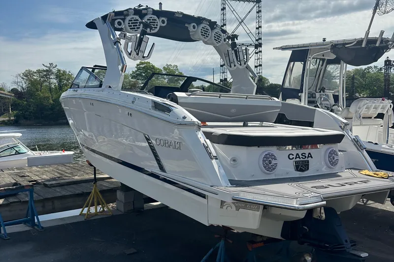 Slide: The Image of 2022 Cobalt R8 Surf boat docked, featuring sleek design and advanced audio system. - 2