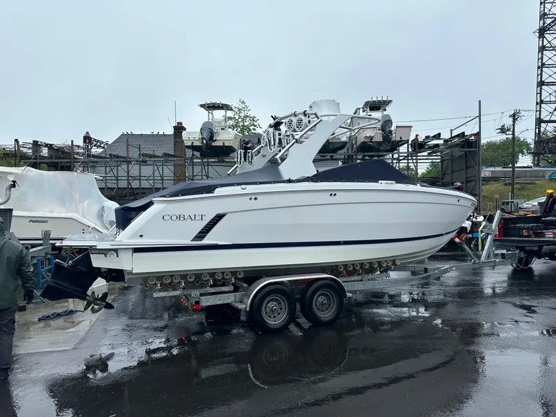 Slide: The Image of 2022 Cobalt R8 Surf boat on trailer in a wet marina setting. - 3