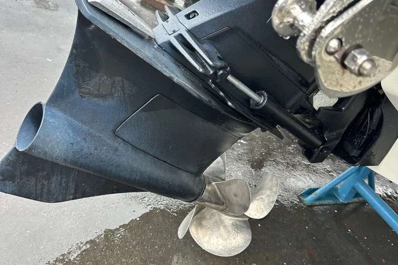 Slide: The Image of 2022 Cobalt R8 Surf boat propeller and outdrive close-up on a wet surface. - 30