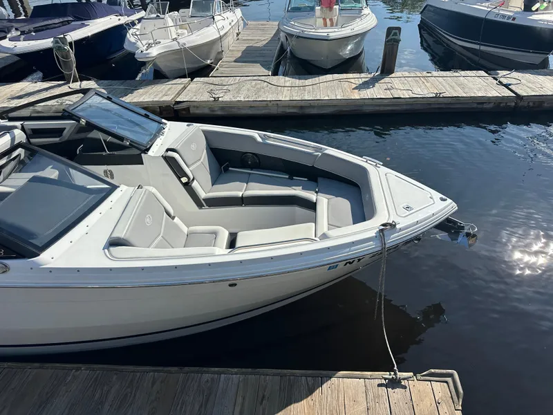 Slide: The Image of 2022 Cobalt R8 Surf boat docked at a marina, featuring sleek design and spacious seating. - 37