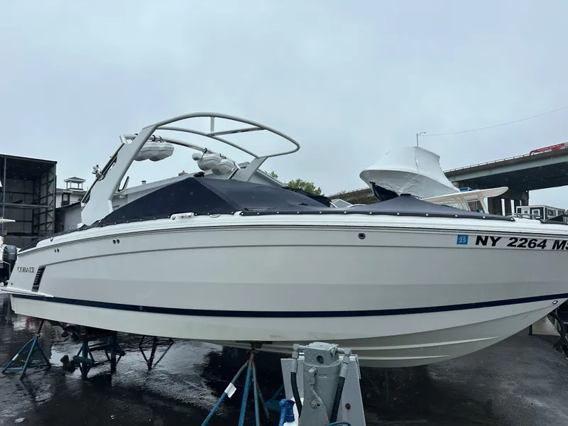 Slide: The Image of 2022 Cobalt R8 Surf boat on display, white exterior, parked on a wet surface. - 6