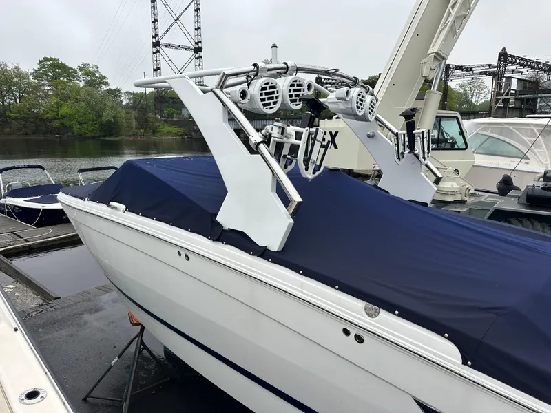 Slide: The Image of 2022 Cobalt R8 Surf boat with blue cover docked near water. - 7