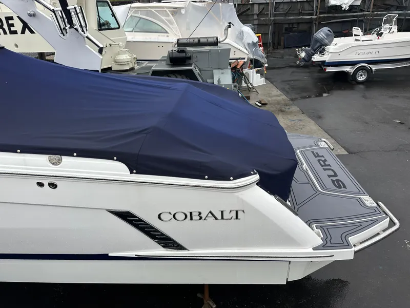 Slide: The Image of 2022 Cobalt R8 Surf boat with cover, docked in a marina. - 8