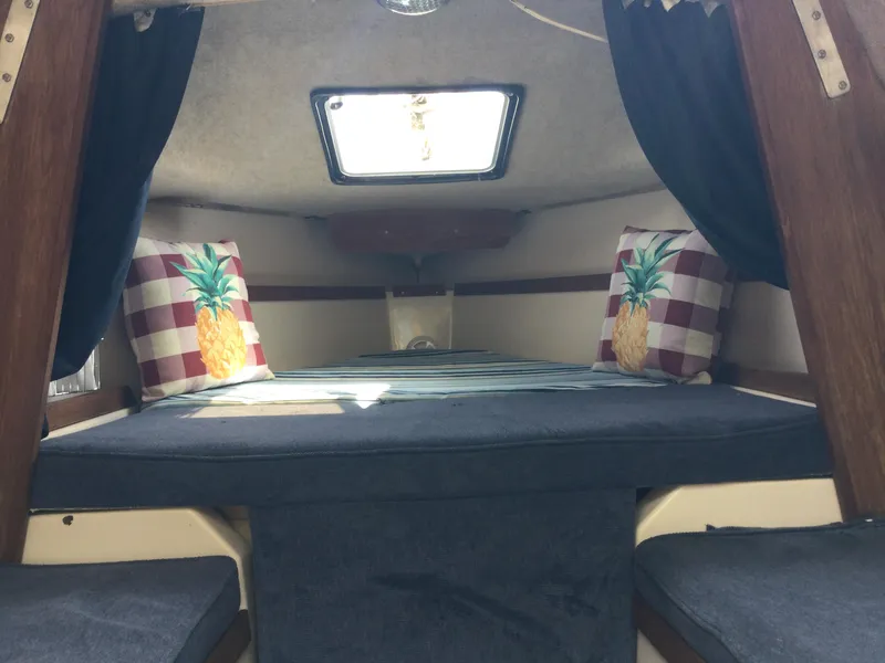 Slide: The Image of Cozy cabin interior of 1987 Precision P23 sailboat with pineapple-themed pillows and skylight. - 11