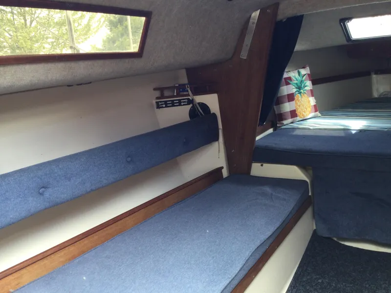 Slide: The Image of Interior of a 1987 Precision P23 sailboat with blue cushions and wooden accents. - 12