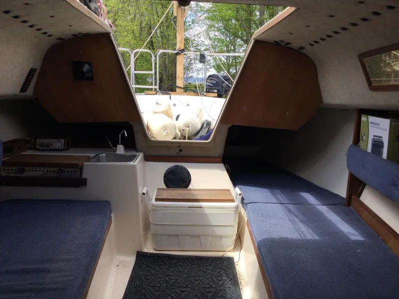 Slide: The Image of Interior of a 1987 Precision P23 sailboat with blue seating and compact kitchenette. - 14