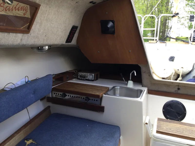Slide: The Image of Interior of a 1987 Precision P23 sailboat with seating, sink, and wooden accents. - 18