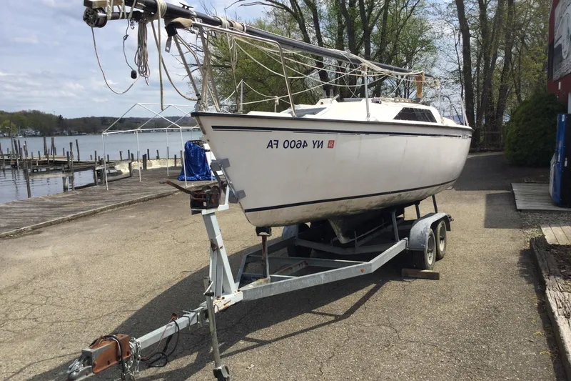 Slide: The Image of 1987 Precision P23 sailboat on trailer near a lakeside dock. - 4