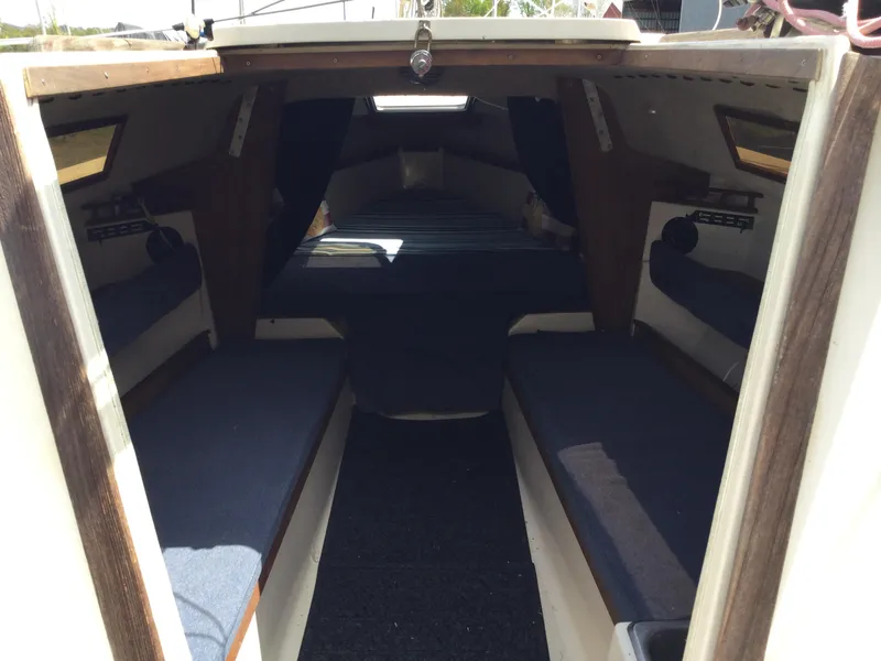 Slide: The Image of Interior of a 1987 Precision P23 sailboat with blue cushions and wooden accents. - 9