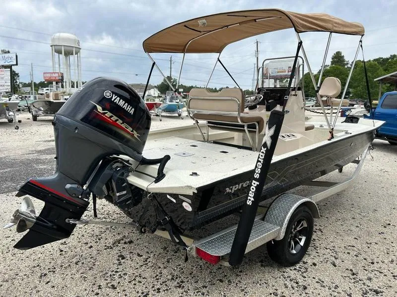 Slide: The Image of 2021 Xpress H20B boat with Yamaha engine, parked on a trailer, under cloudy skies. - 4