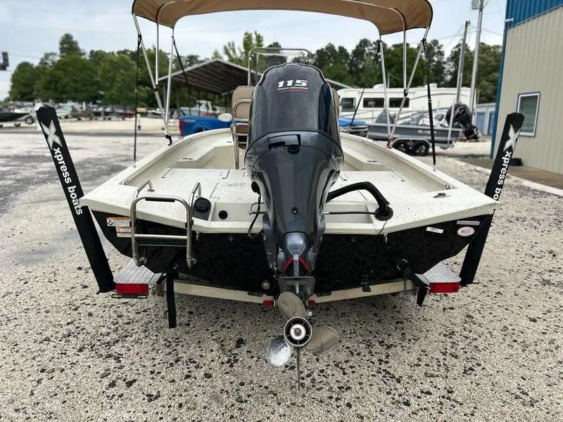Slide: The Image of 2021 Xpress H20B boat with outboard motor, parked on gravel near storage facility. - 5