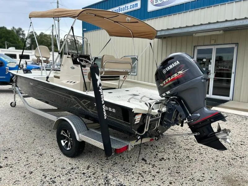 Slide: The Image of 2021 Xpress H20B boat with Yamaha engine on trailer, parked outside a building. - 6