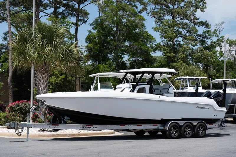 The Image of 2023 Sunsation 32 CCX boat on trailer, parked outdoors with trees in background. - 0
