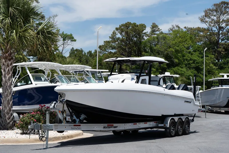 Slide: The Image of 2023 Sunsation 32 CCX boat on trailer, parked outdoors near other boats. - 1