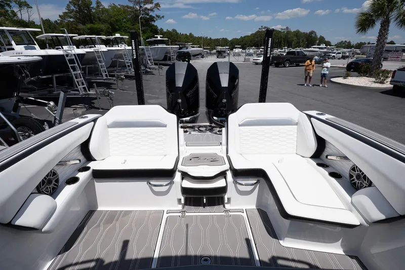 Slide: The Image of 2023 Sunsation 32 CCX boat interior with sleek seating and dual engines in a marina setting. - 10
