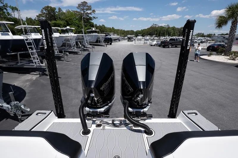 Slide: The Image of 2023 Sunsation 32 CCX boat with dual engines, parked outdoors under a clear sky. - 12