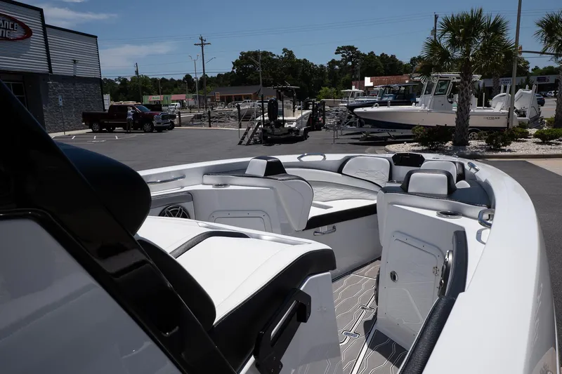 Slide: The Image of 2023 Sunsation 32 CCX boat interior with sleek seating and modern design in a marina setting. - 20