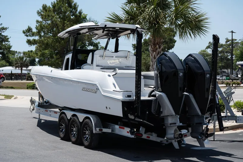 Slide: The Image of 2023 Sunsation 32 CCX boat on trailer, dual engines, parked outdoors. - 3