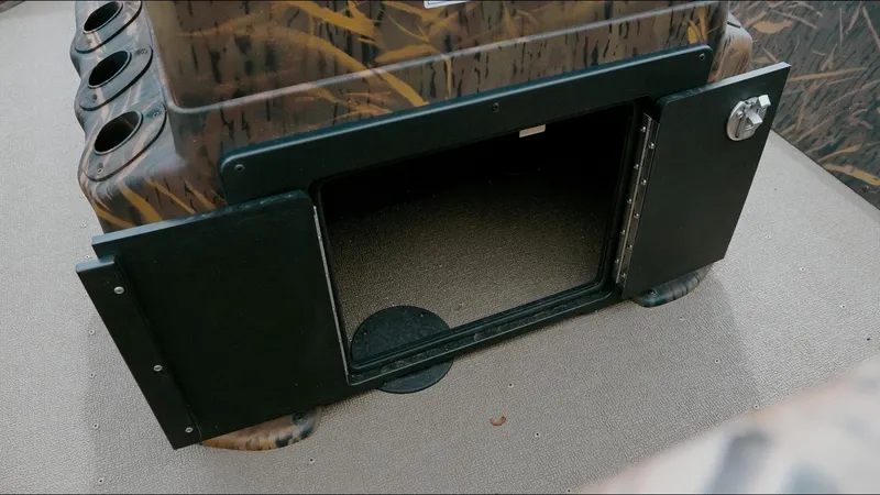 Slide: The Image of Open storage compartment on 2025 G3 18CC boat with camouflage design. - 12