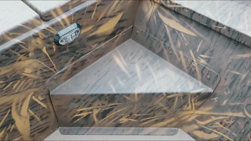 Slide: The Image of Camouflage-patterned interior of a 2025 G3 18CC boat with a triangular seat. - 18