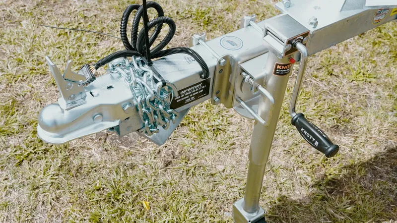 Slide: The Image of Trailer hitch with chains and lock on grass, G3 18CC 2025 model. - 2