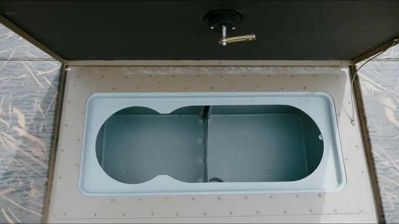 Slide: The Image of 2025 G3 18CC boat storage compartment with open lid and handle. - 6