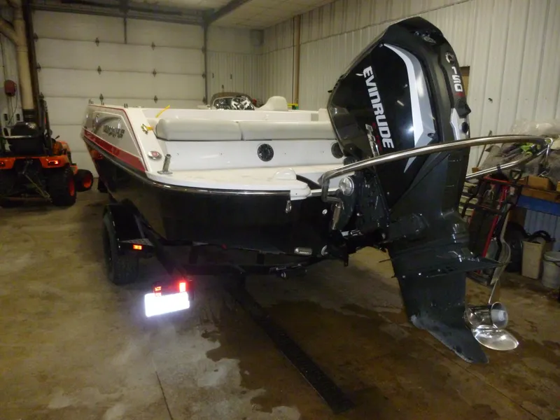 Slide: The Image of 2018 Starcraft 211 MDX boat with Evinrude motor in a garage setting. - 6