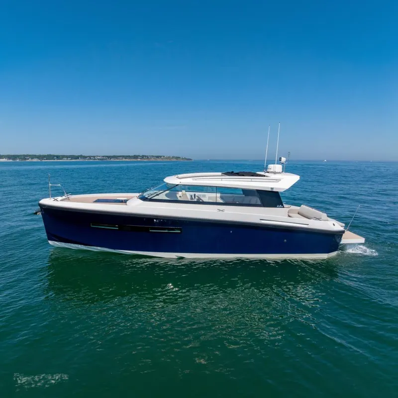 The Image of 2023 Delta Powerboats 33 Coupe cruising on open water under clear blue skies. - 0