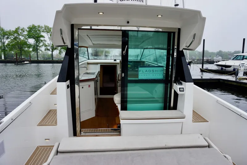 Slide: The Image of 2023 Delta Powerboats 33 Coupe, rear view, docked with open cabin door. - 16