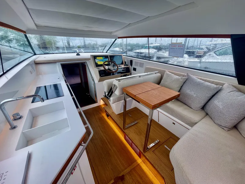 Slide: The Image of Interior of 2023 Delta Powerboats 33 Coupe, featuring modern helm, seating, and kitchenette. - 18