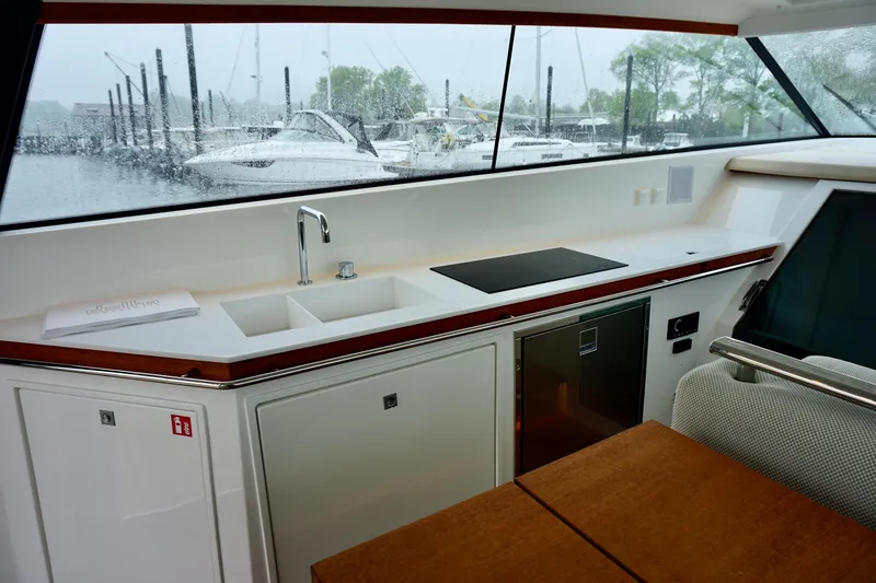 Slide: The Image of Interior of 2023 Delta Powerboats 33 Coupe with kitchenette and marina view. - 20