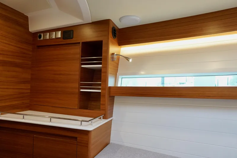 Slide: The Image of Interior of 2023 Delta Powerboats 33 Coupe, featuring sleek wood paneling and modern design. - 22