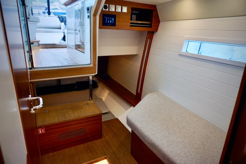 Slide: The Image of Interior of 2023 Delta Powerboats 33 Coupe, featuring modern wood and white paneling. - 23