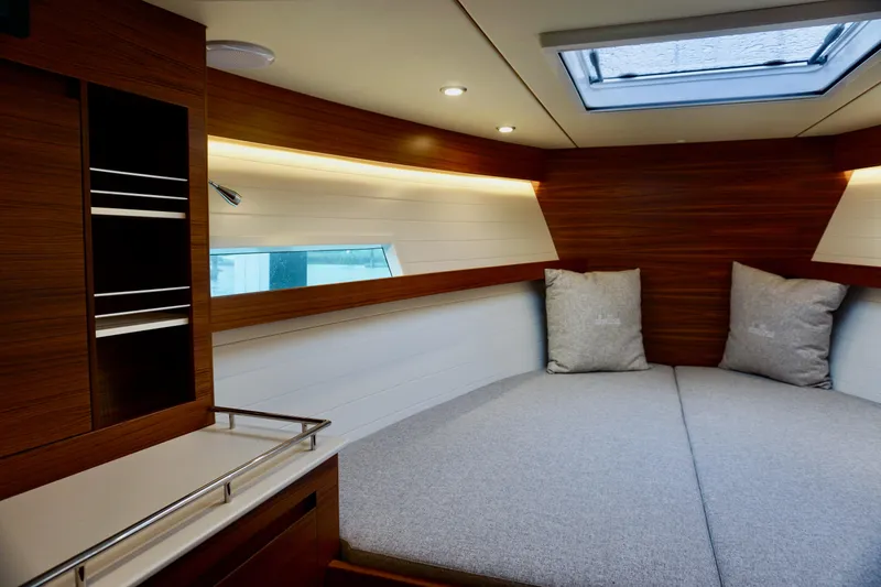 Slide: The Image of 2023 Delta Powerboats 33 Coupe interior with cozy bed and modern wood finish. - 29