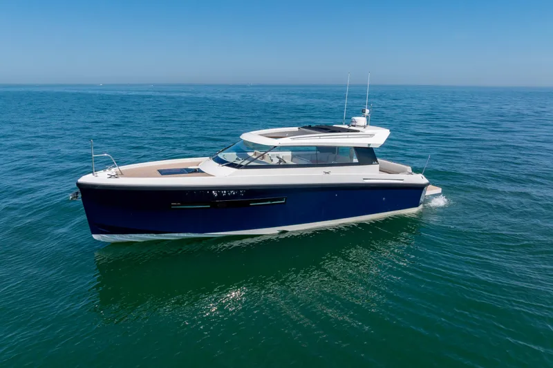 Slide: The Image of 2023 Delta Powerboats 33 Coupe cruising on open water under clear skies. - 34