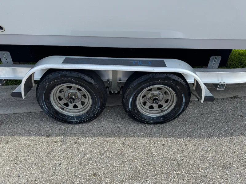 Slide: The Image of Trailer wheels for 2020 Cobia 220 Center Console boat on pavement. - 12