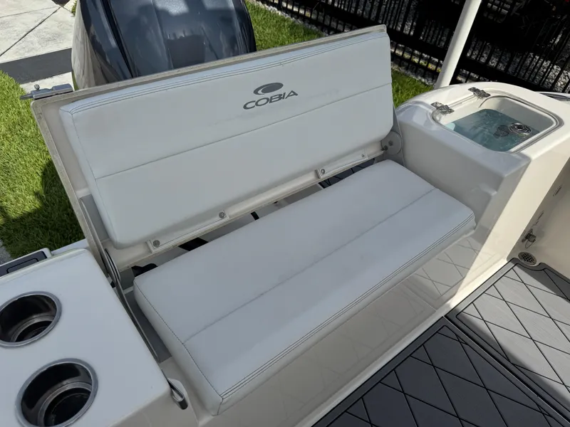 Slide: The Image of 2020 Cobia 220 Center Console boat with cushioned seating and cup holders. - 14
