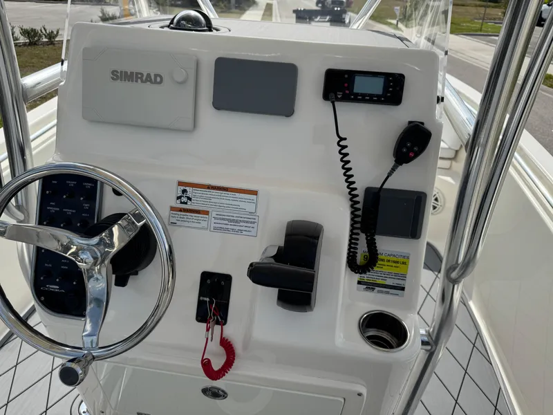 Slide: The Image of 2020 Cobia 220 Center Console dashboard with steering wheel and navigation equipment. - 16