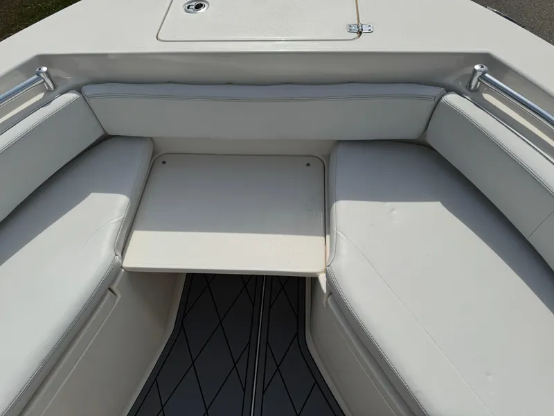 Slide: The Image of 2020 Cobia 220 Center Console boat interior with cushioned seating and table. - 27