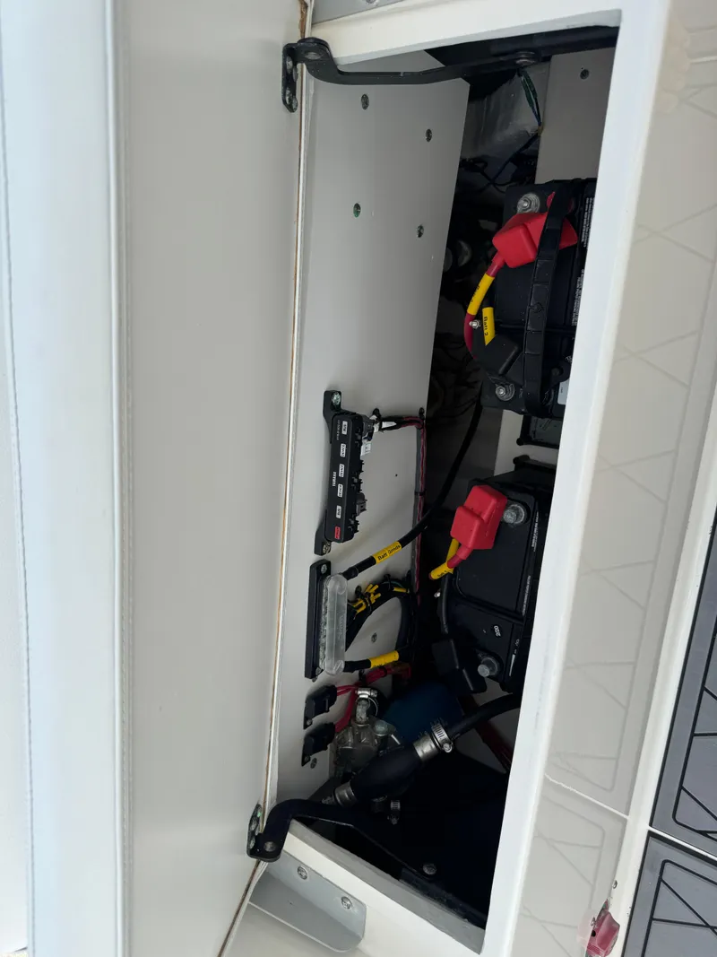 Slide: The Image of 2020 Cobia 220 Center Console battery compartment with wiring and components. - 33